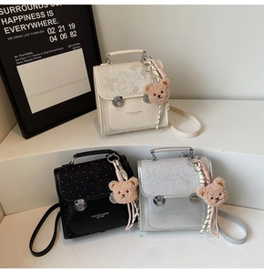 Detailed view of three mini PU leather flap bags with retro buckles and bear charms