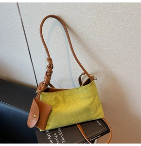 Dettaglio borsa tote verde scamosciata con tracolla in pelle e mini portamonete