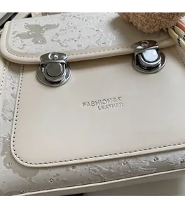 Detailed close-up of cream white retro handbag featuring jacquard butterfly patterns and metal buckles