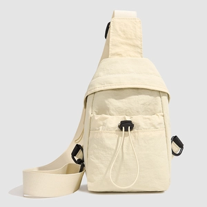 Detail of off-white nylon crossbody bag showing toggle drawstring pocket and fabric texture