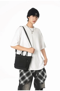 Detail of waterproof black nylon tote bag with top handle and adjustable shoulder strap