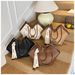 Detail of woven tote bags in various colors with elegant silk ribbons and retro plaques