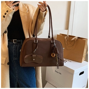 Dettaglio borsa scamosciata testa di moro con nappina a frange e tasche vintage