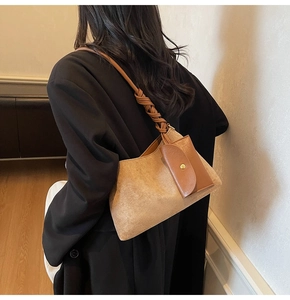 Detail of camel suede tote bag featuring a brown woven strap and external leather pocket