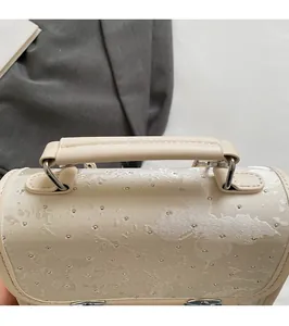 Detail of beige backpack with glitter butterfly motif and reinforced top handle strap