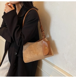 Detail of brown faux suede shoulder bag with woven strap and detachable small purse