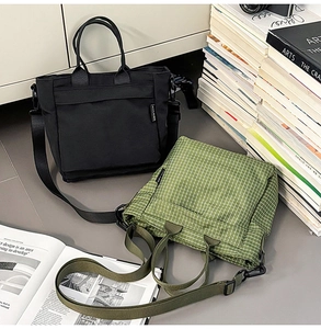Detailed view of black and green plaid canvas tote bags with adjustable straps