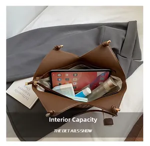 Detail view of large brown woven tote bag interior showing spacious capacity for tablets