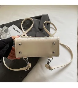 Detailed view of cream-colored PU leather bag base with four silver metal protective studs