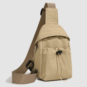 Close-up of khaki nylon crossbody bag showing drawstring pocket and durable strap details