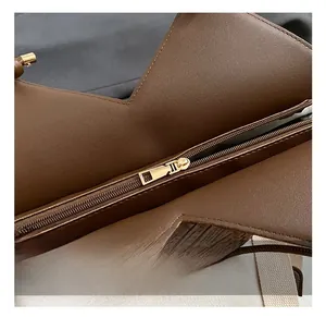 Detail view showing golden metal zipper and woven leather texture of the tote bag