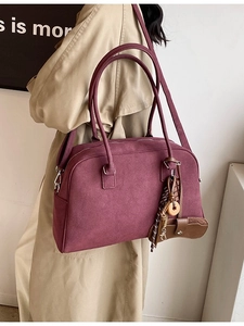 Borsa Boston bordeaux in pelle scamosciata con ciondoli vintage indossata da modella