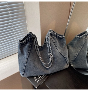 Detail view of retro blue denim tote bag with chain strap in a lifestyle setting