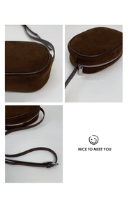 Detail view of brown suede shoulder bag showing smooth zipper and premium leather texture