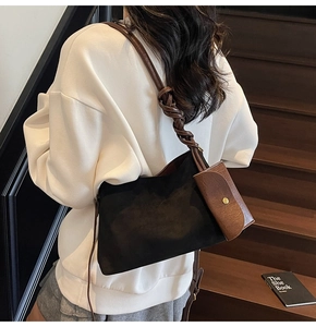 Detail view of suede patchwork crossbody bag with thick woven shoulder strap and mini pouch