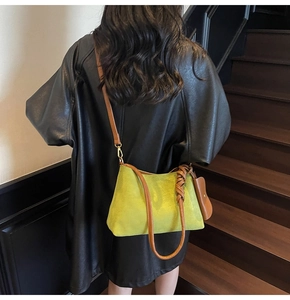 Detail of lime green suede tote with brown leather strap and mini pouch on model