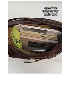 Top view of large capacity brown suede shoulder bag showing interior with books and umbrella