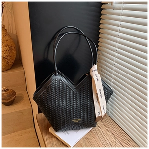Detail of woven black leather tote with V-opening and beige decorative silk ribbon
