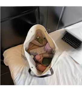 Spacious interior of beige canvas tote bag showing storage for laptop and essentials