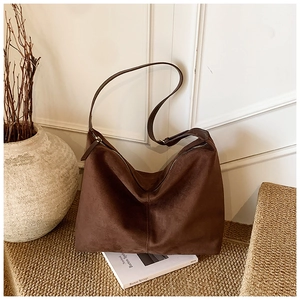 Vue macro détaillée de la texture daim marron foncé et des coutures d'un grand sac cabas