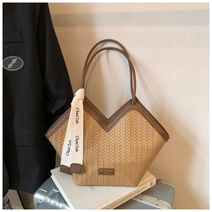 Detail of woven tote bag featuring a V-shaped opening and decorative fashion ribbon strap