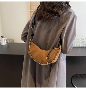 Brown frosted croissant bag with metallic chain detail and leather strap on a model
