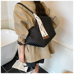 Detail of black woven leather tote bag with a decorative silk scarf on the side strap