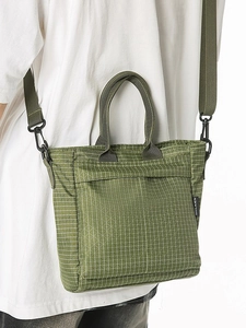 Large olive green grid tote bag with adjustable shoulder strap shown on a model back view
