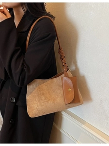 Suede hobo bag in camel brown with woven strap and mini pouch shown from a side view