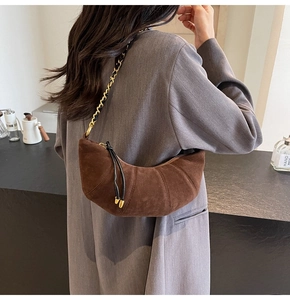Detail showing the suede texture and chain strap of this brown croissant shoulder bag
