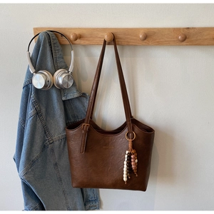 Detail of vintage brown leather tote bag with unique wood beads and shoulder strap
