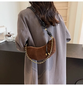 Brown frosted dumpling bag with pleated texture and golden chain on a female model