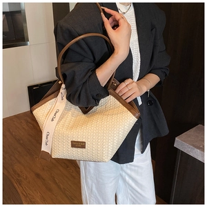 Detail of retro woven tote bag with brown leather trim and fashion brand tag