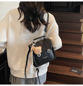 Black leather mini backpack featuring silver buckles and cute brown bear pendant charm