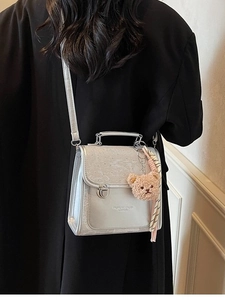Fashionable silver-grey backpack with ostrich texture flap and teddy bear pendant