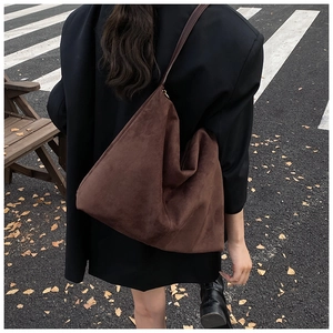 Sac cabas en daim marron de profil montrant la grande capacité et la texture souple