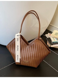 Brown woven tote bag with V-shaped opening and lettered ribbon strap for daily commute