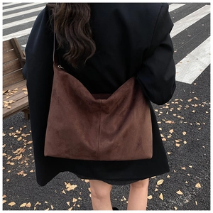 Sac cabas en daim marron avec coutures verticales dans une scène urbaine d'automne