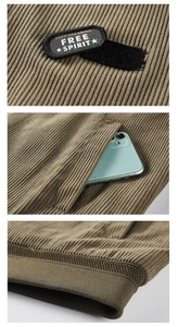 Detail view of corduroy jacket with embroidered patch, large pocket and ribbed cuffs