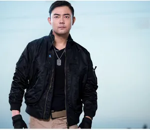 Close-up of black tactical bomber jacket with military utility pockets and ribbed cuffs