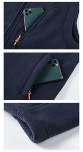 Detail of dark blue fleece vest featuring zippered side pockets and soft textured fabric