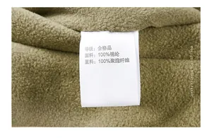 Detail of the washing label on a green fleece vest showing fabric content and care info