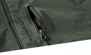 Macro shot of durable metal zippers and textured olive green fabric on a men's jacket