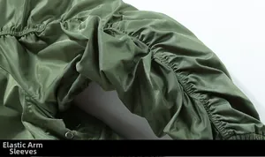 Detail of army green bomber jacket featuring elasticated pleated sleeves and metal snaps