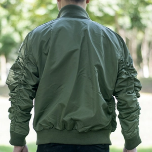 Olive green MA-1 flight jacket with ruched sleeves and ribbed cuffs in outdoor setting