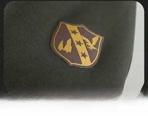 Detail of the military-style embroidered patch on the sleeve of a dark olive parka