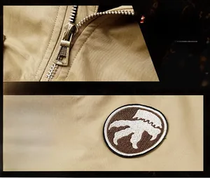 Detail of khaki jacket with premium metal zipper and embroidered outdoor badge