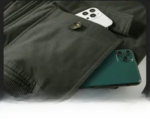 Detail of a deep green parka flap pocket with button showing large storage capacity