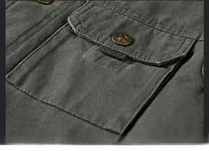 Dettaglio della giacca cargo verde militare con trama twill e tasca a patta con bottone in metallo