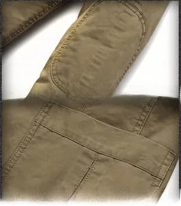 Detail view of khaki cotton jacket showing elbow patch and large utility pocket design